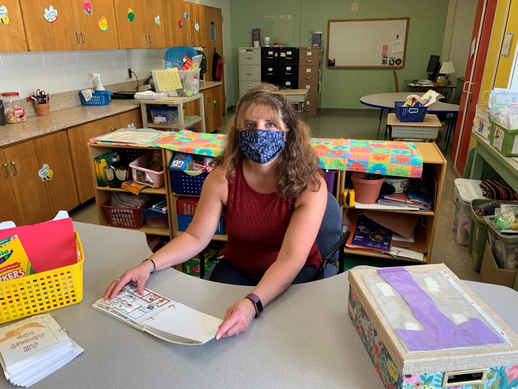 teacher sitting at her desk in a classroom