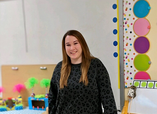 virtual teacher poses for photo in her classroom