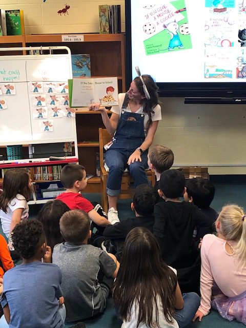 teacher reads to students in a library setting