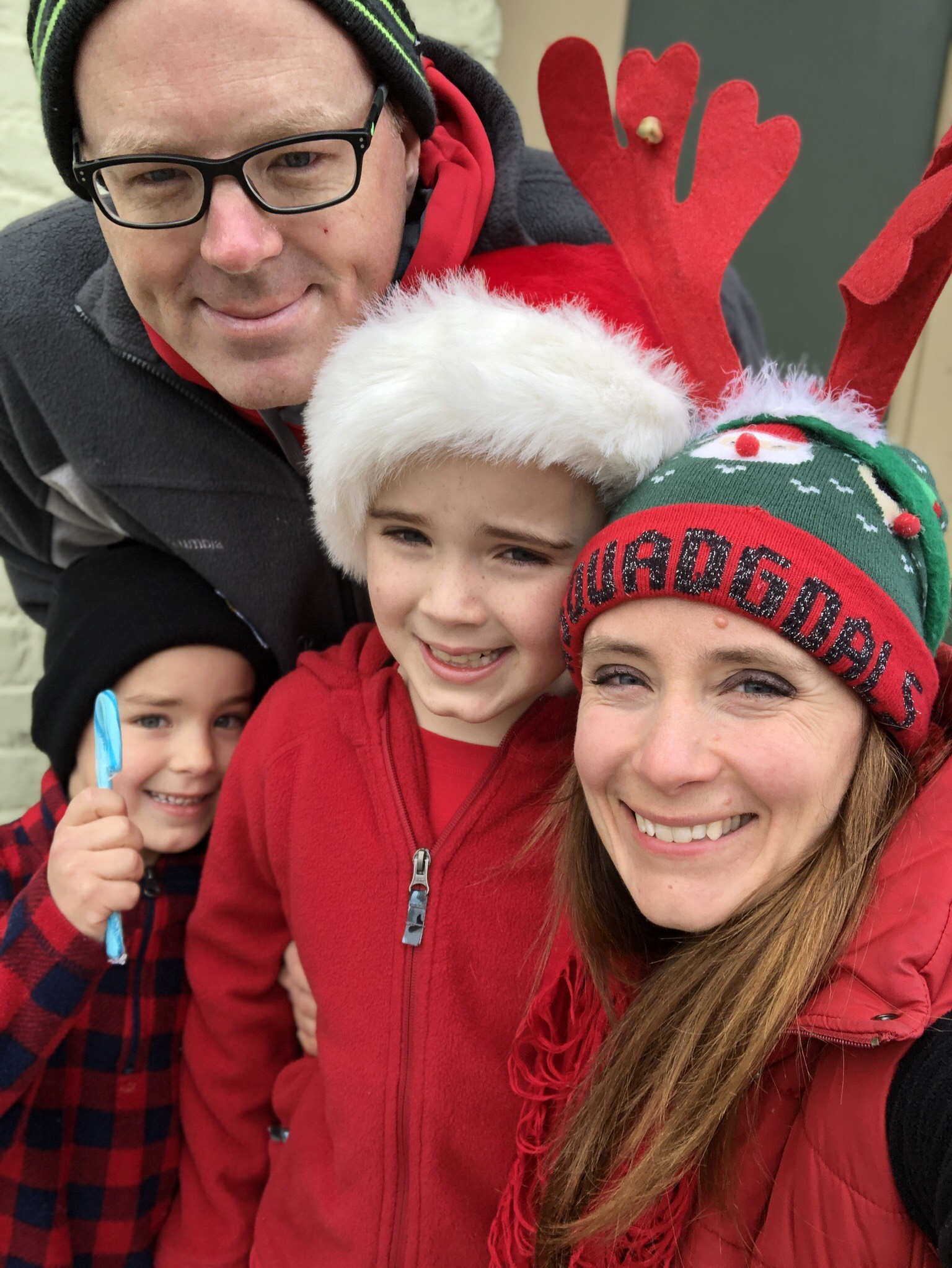 family posing for a picture wearing holiday hats