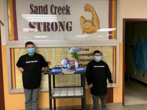 Sand Creek Middle School life skill students posing with their Kindness Cart.