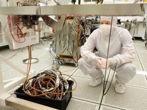 CCHS alumnus Sean O'Brien and the first assembled sealing station installed to the sample collection system mounting structure.