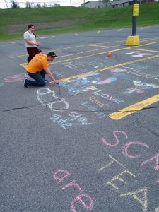 Pictures of students using chalk in the parking lot