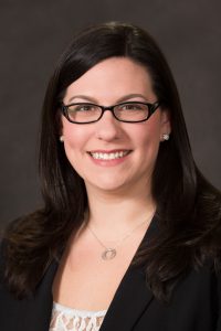 headshot of a women in a black business suit with a white shirt