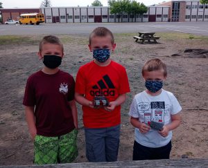 three kids standing together outside