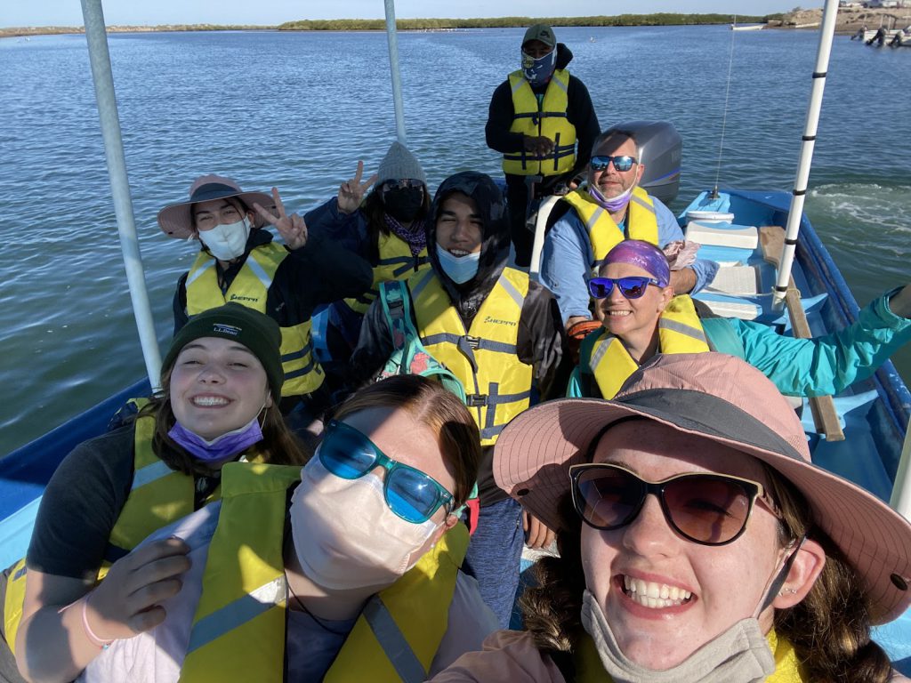 students gathering on a boat for a selifie