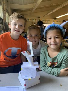 students pose in front of their index card structure