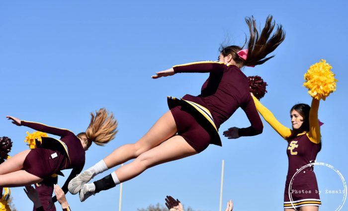 photo of three cheerleaders in the air during routine