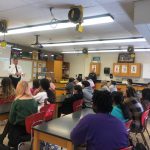 students sit and listen to presentation