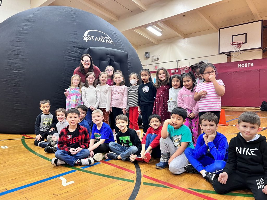 Students smile outside of the Starlab portable planetarium