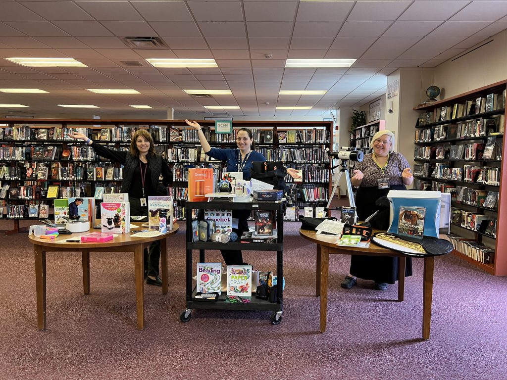 staff standing behind a display of kits at the library