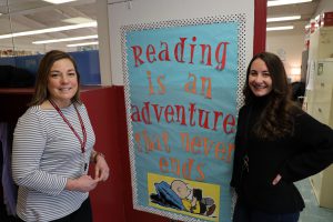 Headshot of two women with a sign that says "Reading is an adventure that never ends."