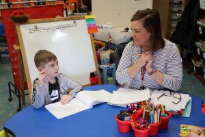 Teacher smiling with student in the classroom