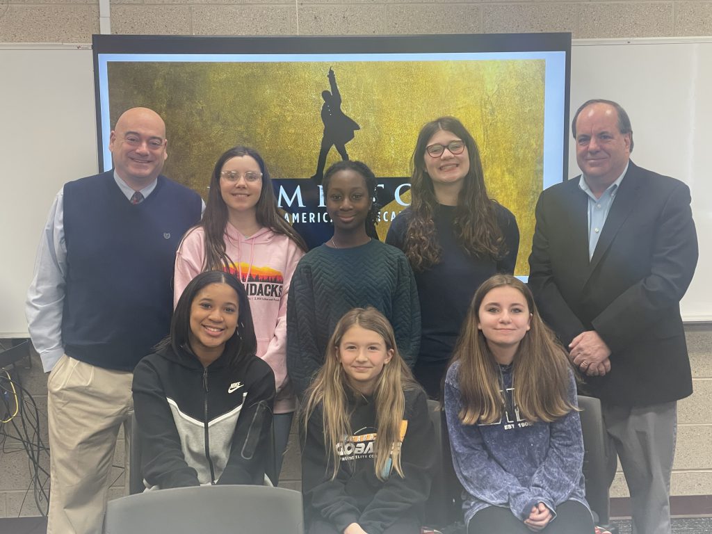 a group of six female students and two male adults pose for a photo.