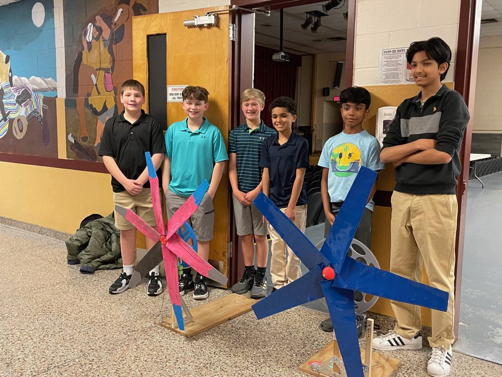 a group of students standing behind their turbine.