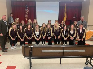 a group of cheerleaders posing for a photo with the superintendent and board of education president. 