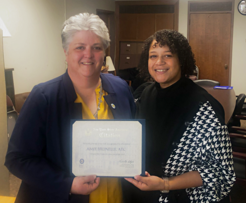 two people standing next to each other holding a certificate