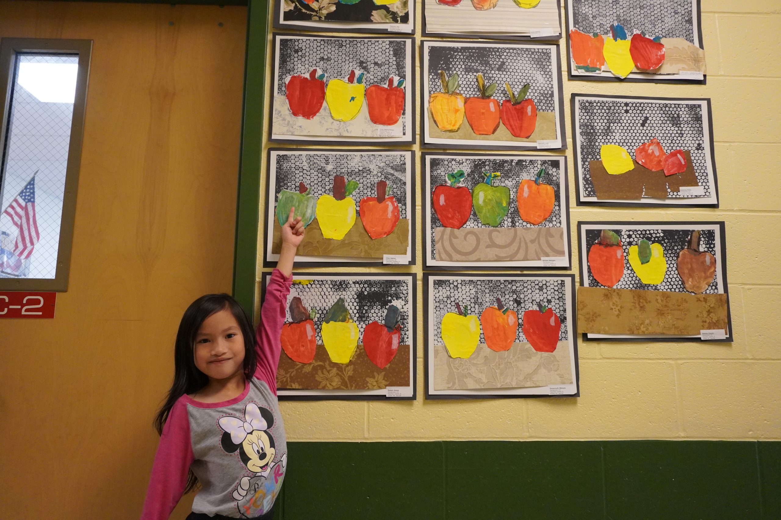 Student shows their drawing of apples