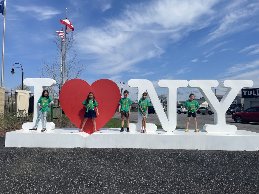 students stand in front of the I love New York Sign.