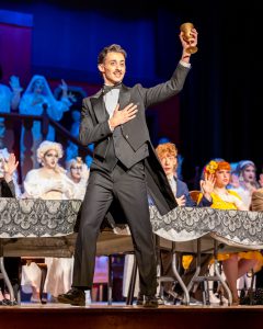 Students perform the Addams Family musical on stage.