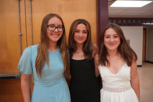 Three students pose for a photo before they take the stage at the Sand Creek Moving up Ceremony. 