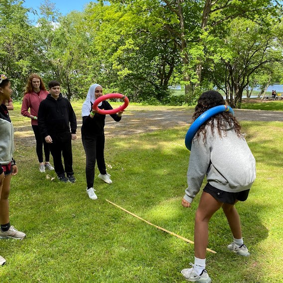 students use rings during human ring toss game