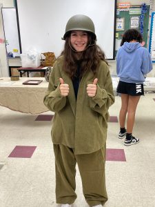 student tries on uniform of past soldiers