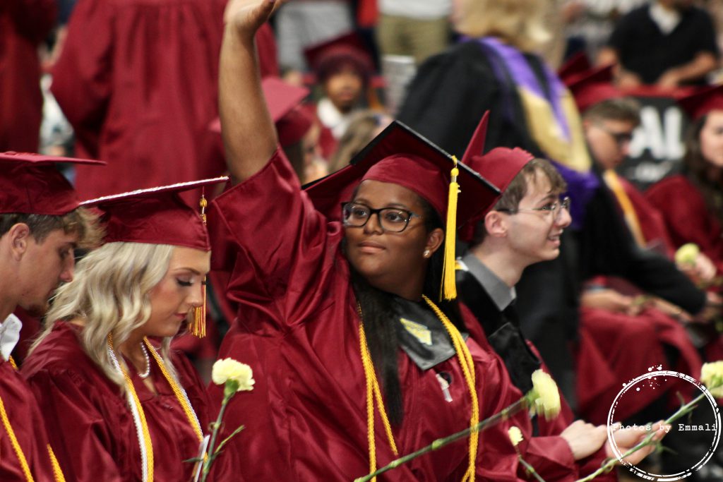 Student waves to family member at graduation. 