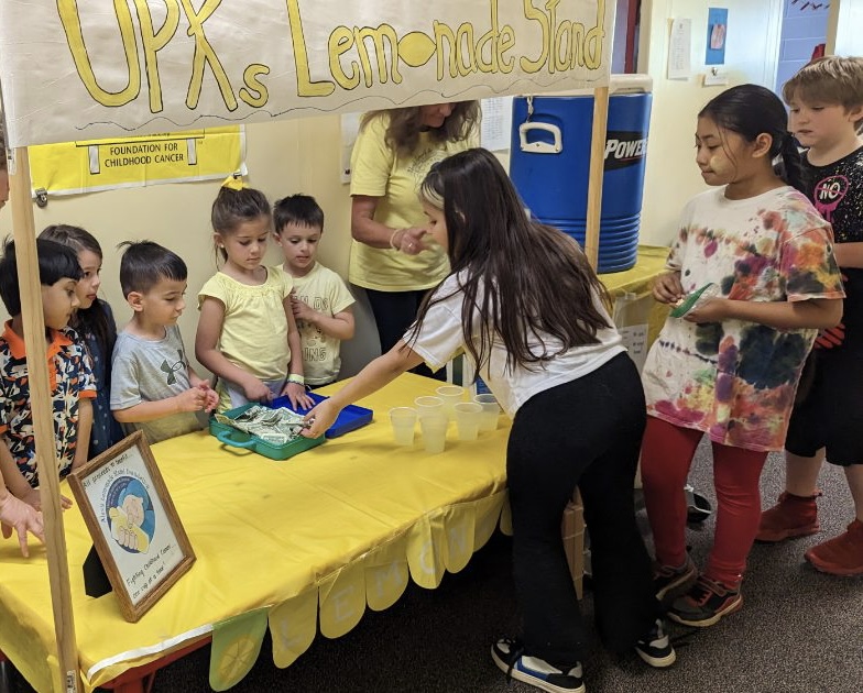 students working a lemonade stand at school