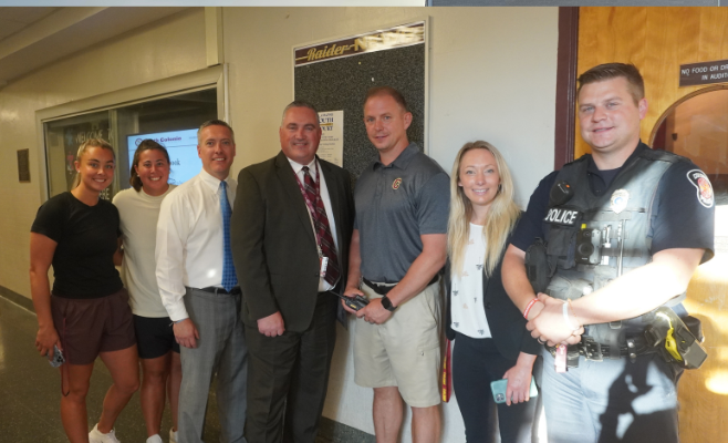 school administrators and teachers pose for a photo on the first day of school.