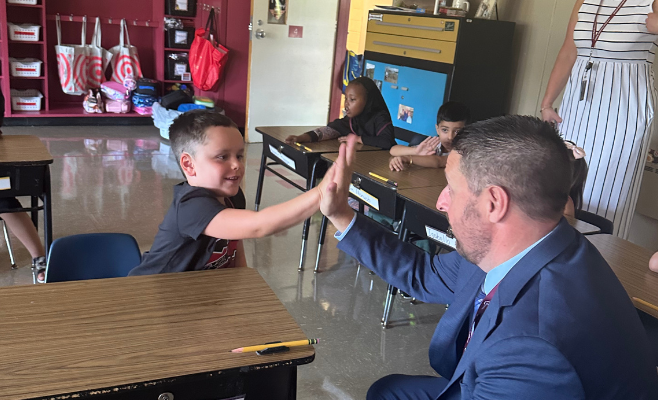 Forest Park new principal Mr. Luke welcomes student to school on their first day with a high five.