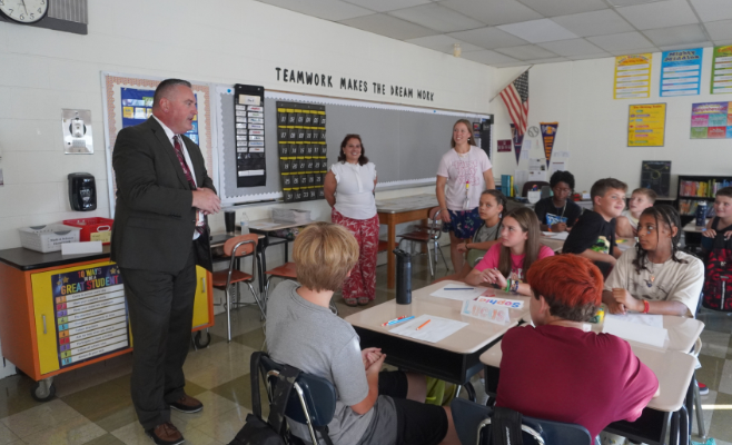 superintendent speaks to students in the classroom.