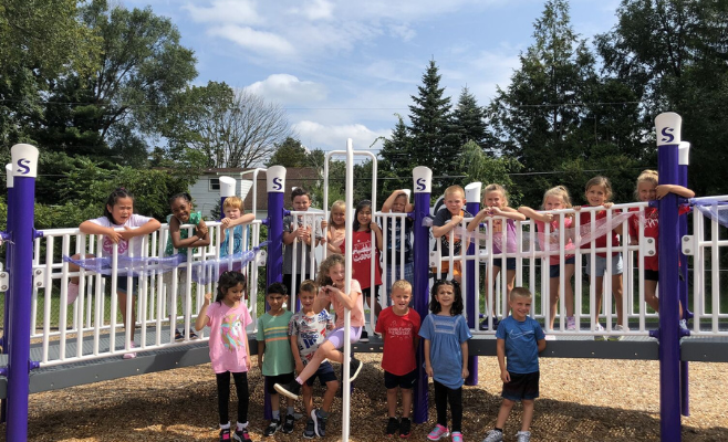 students pose for a photo on the playground