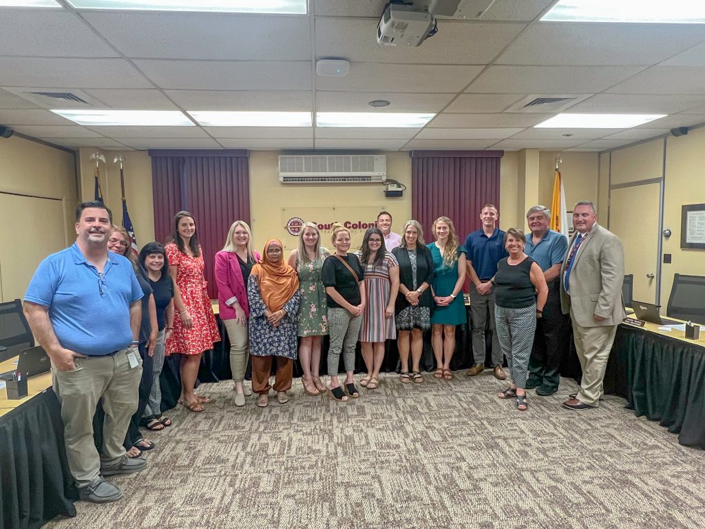 Board of education members posing for a photo with tenured teachers.