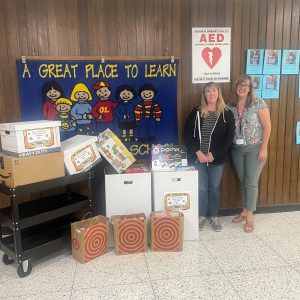 two adults standing next to boxes of snacks