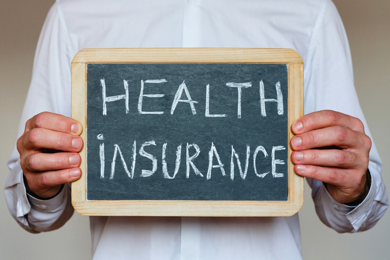 Person holding Health Insurance sign Person holding Health Insurance sign