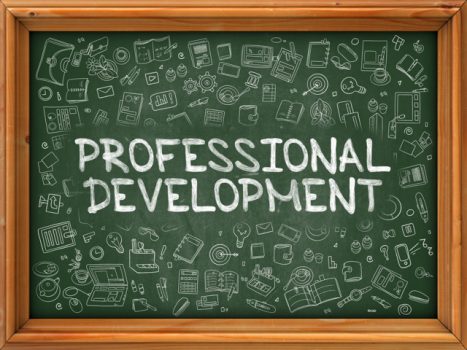 Chalkboard with the words "Professional Development". In the background are miscellaneous educational items.