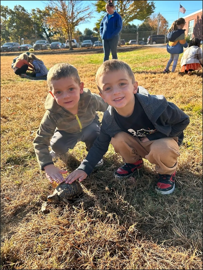 two students petting a turtle