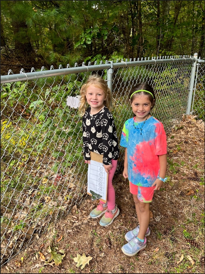 Children posing by a fence