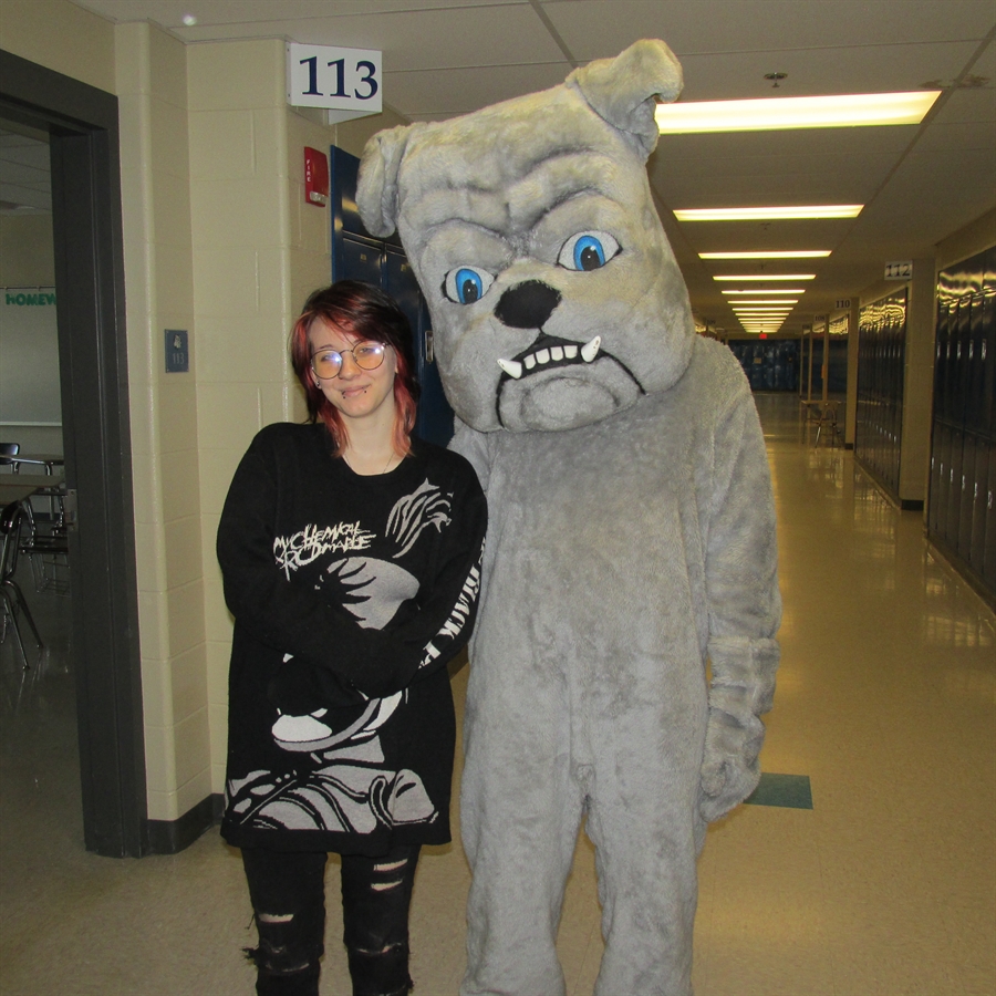 Picture of most improved student with school mascot.