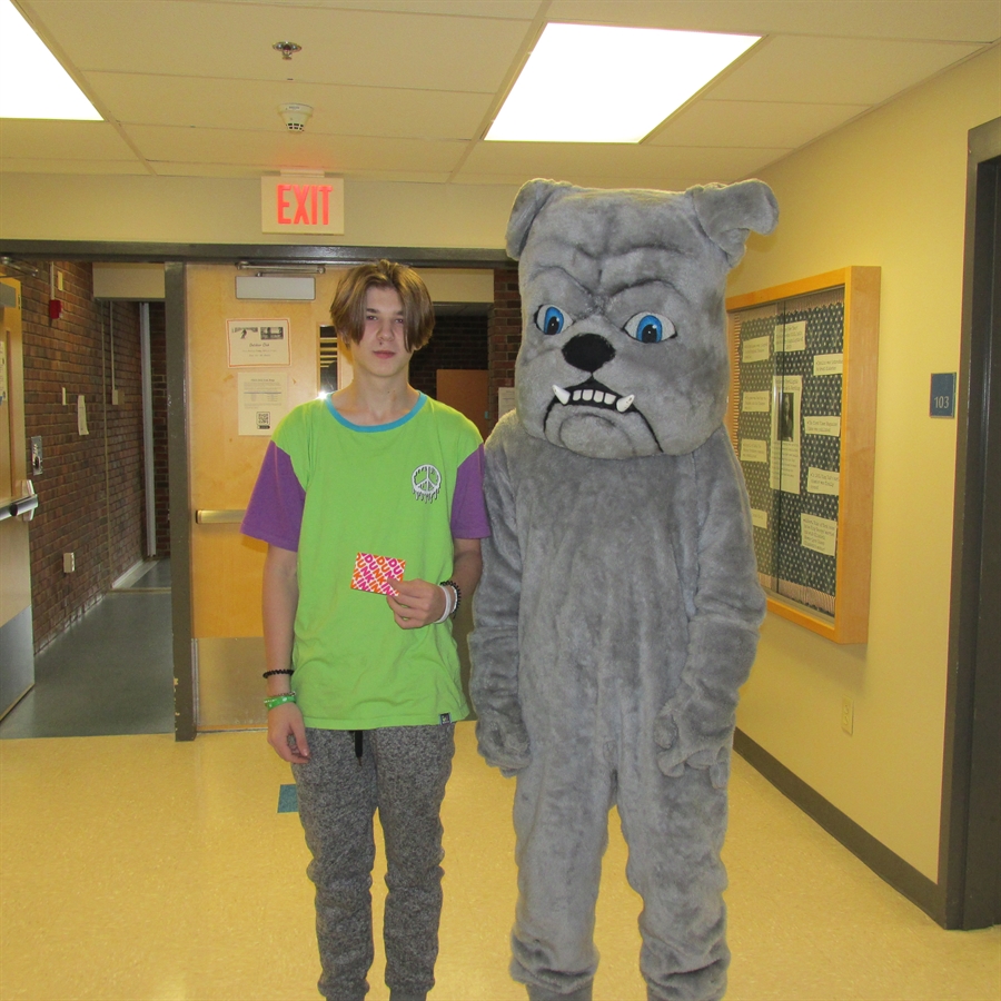 Picture of most improved student with school mascot.