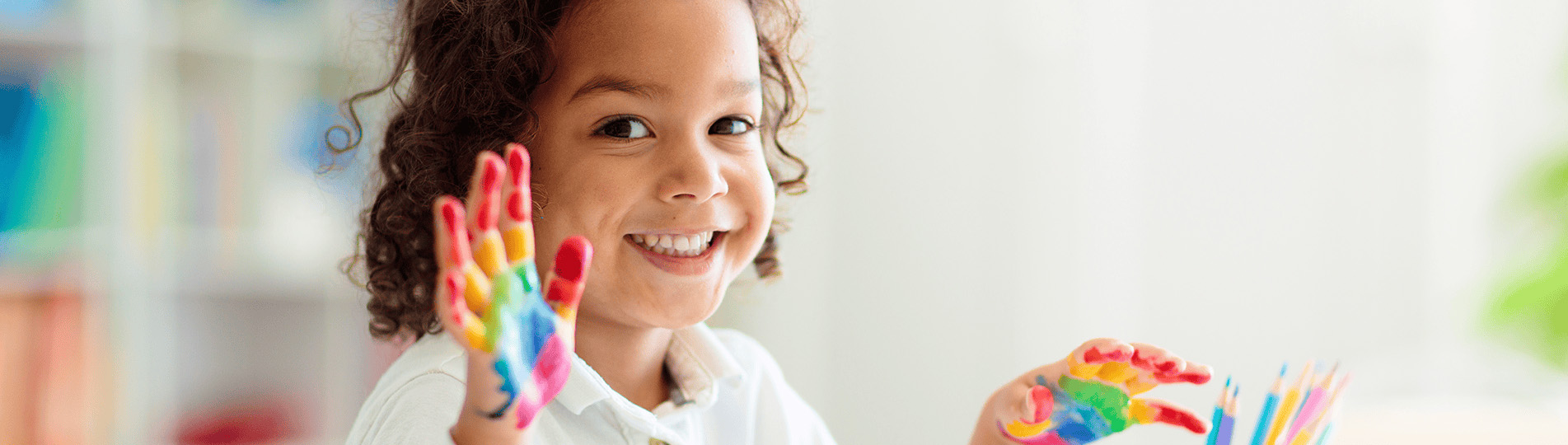 young child with fingerpaint on hands