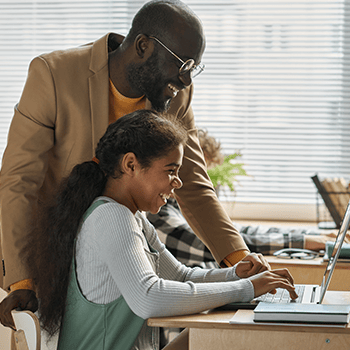 Teacher helping student on laptop