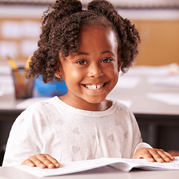 girl smiling over open book