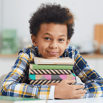 Boy laying his head on stack of books