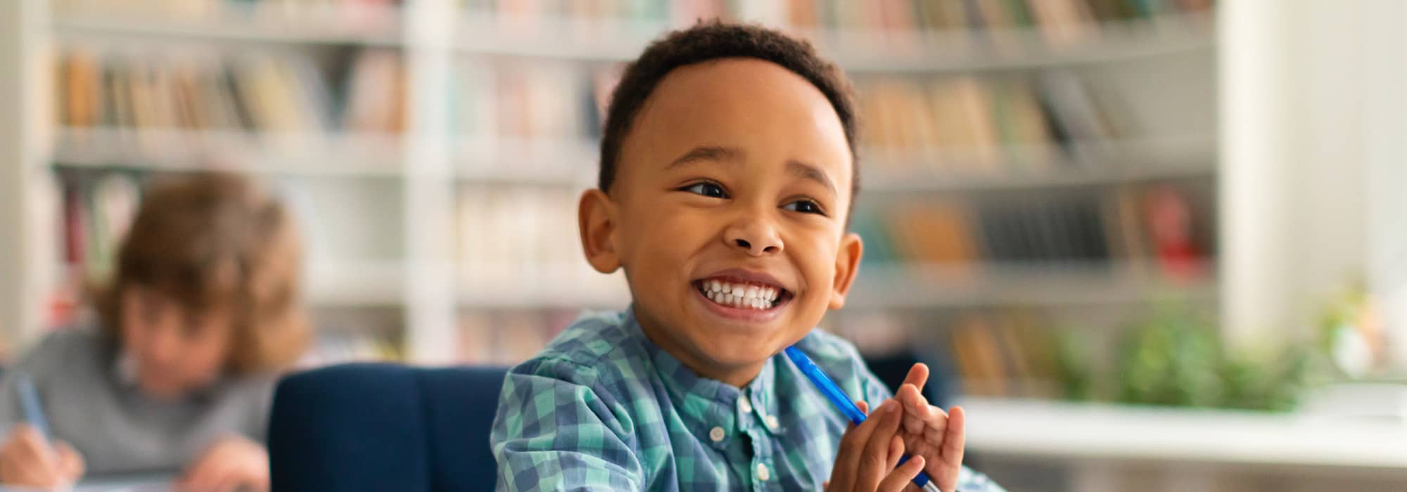 Photo of smiling boy sitting in classroom