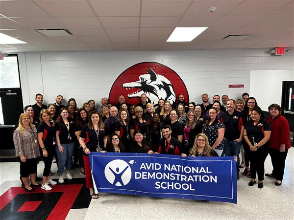   Administrators and staff hold up the AVID National Demonstration School on Validation Day