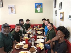 Principal Presley and Several Training and Trades interns enjoy breakfast and discussing their internships 