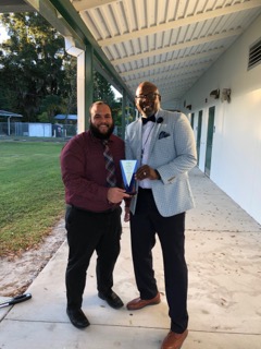 Principal Presley and Assistant Principal Mr. Velazquez posing with the Legacy award from celebrity educator 