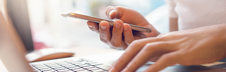 Person with Phone at Computer Person with Phone at Computer